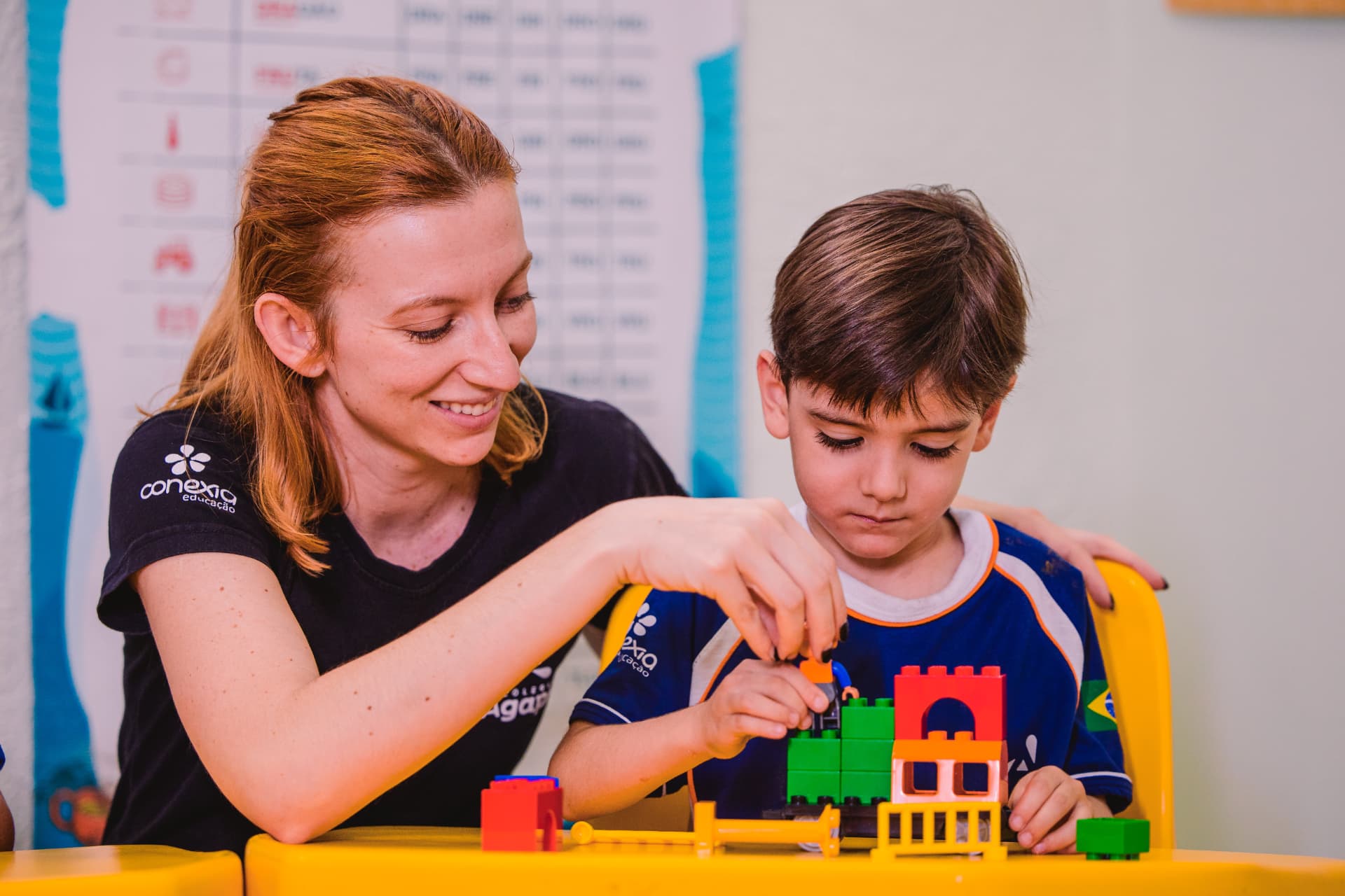 Professora e aluno montando peças LEGO Education